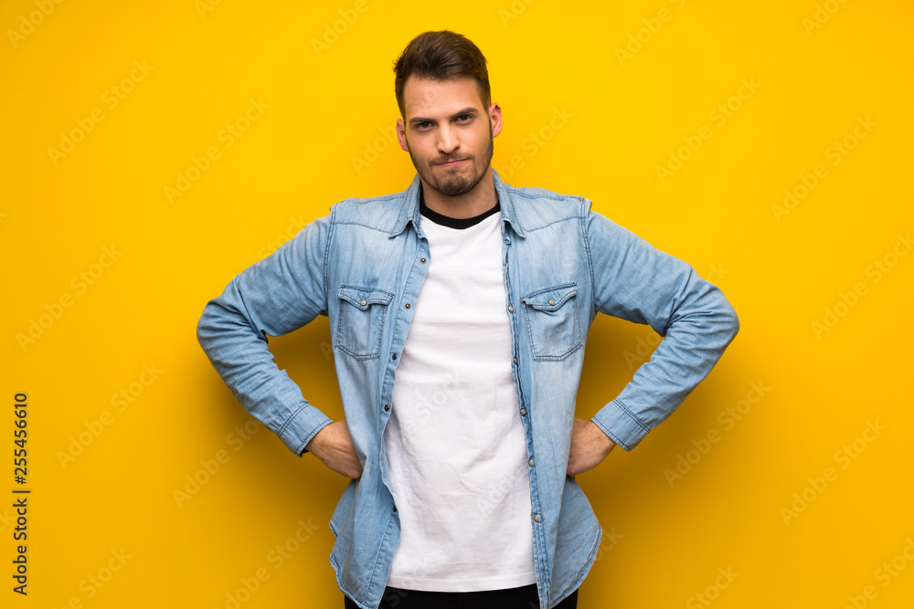 Handsome man over yellow wall angry Handsome man over yellow wall angry