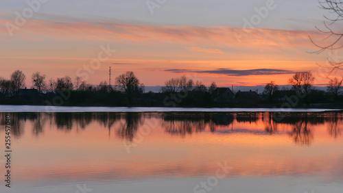 red sunset over the water of a village lake © makam1969