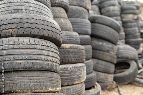 Old worn out tires on an abandoned trash dump. Garbage heap ready for disposal.