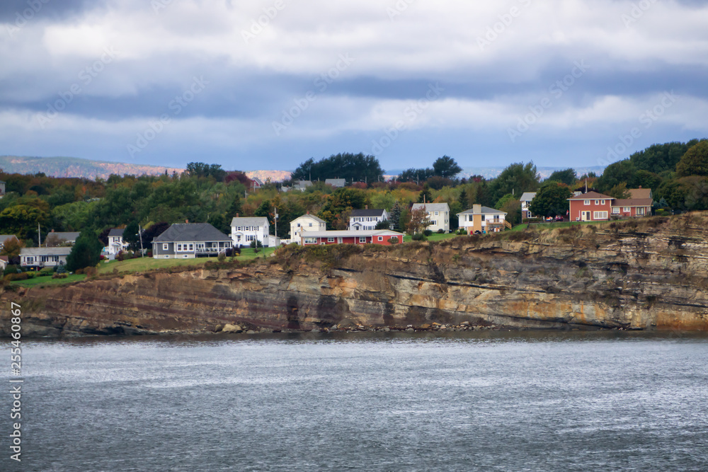Residential homes on a rocky coast during a cloudy day. Taken in North Sydney, Nova Scotia, Canada. Residential homes on a rocky coast during a cloudy day. Taken in North Sydney, Nova Scotia, Canada.