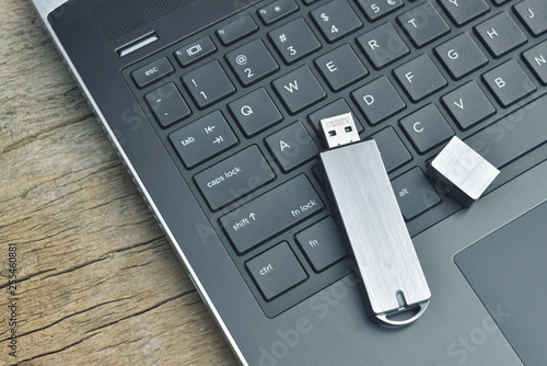 Fényképezés Close up of metal USB flash drive connected to laptop on wood desk