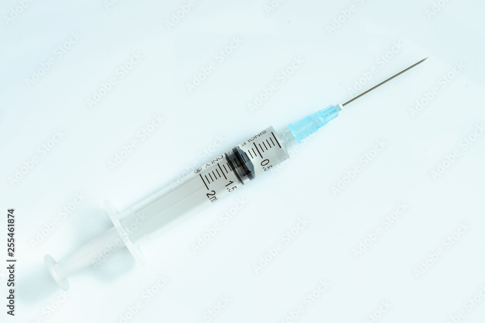 Syringe on a light blue background with medicinal solution. 2 ml syringe close up Syringe on a light blue background with medicinal solution. 2 ml syringe close up