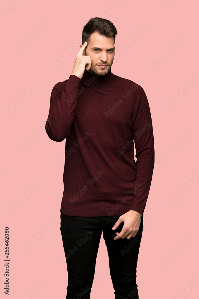 Man with turtleneck sweater having doubts and thinking over pink background Man with turtleneck sweater having doubts and thinking over pink background