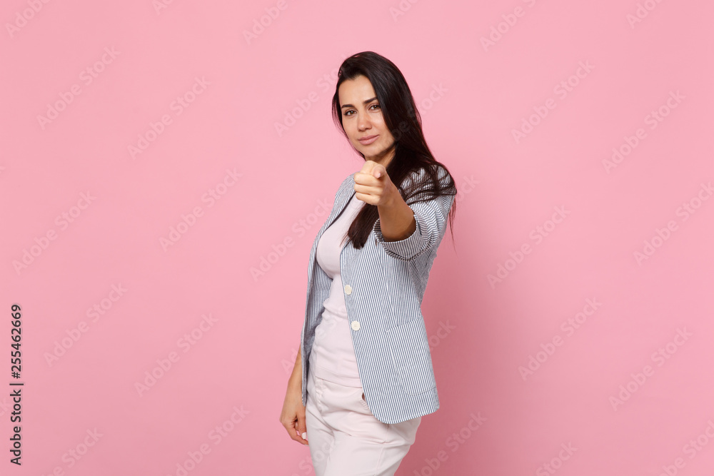 Portrait of smiling young woman in striped jacket pointing index finger on camera isolated on pink pastel wall background in studio. People sincere emotions, lifestyle concept. Mock up copy space. Portrait of smiling young woman in striped jacket pointing index finger on camera isolated on pink pastel wall background in studio. People sincere emotions, lifestyle concept. Mock up copy space.
