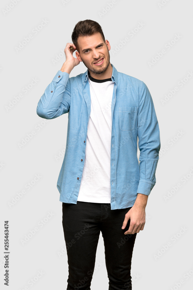 Handsome man having doubts over grey background Handsome man having doubts over grey background