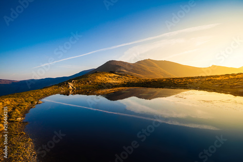 Mountain lake landscape at sunset with peak reflection scenic view