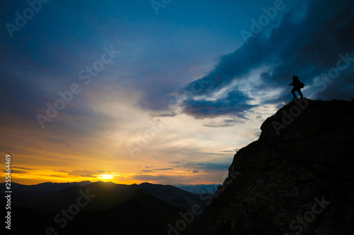 Photographer on top of steep rocks photographing sunset © bdavid32