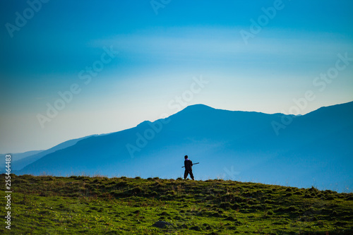 Shepherd walking holding a rod in his hands, mountain landscape photo