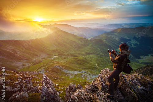 Photographer on top of steep rocks photographing the sunset