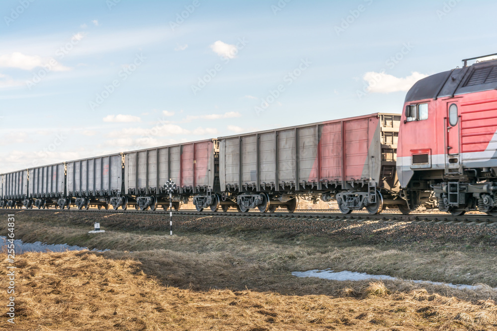 the locomotive and a lot of freight cars are traveling by rail, freight train on rails in the steppe the locomotive and a lot of freight cars are traveling by rail, freight train on rails in the steppe