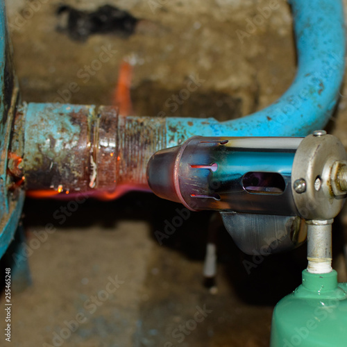 Heating a steel pipe with a blowtorch. The flame of a blowtorch