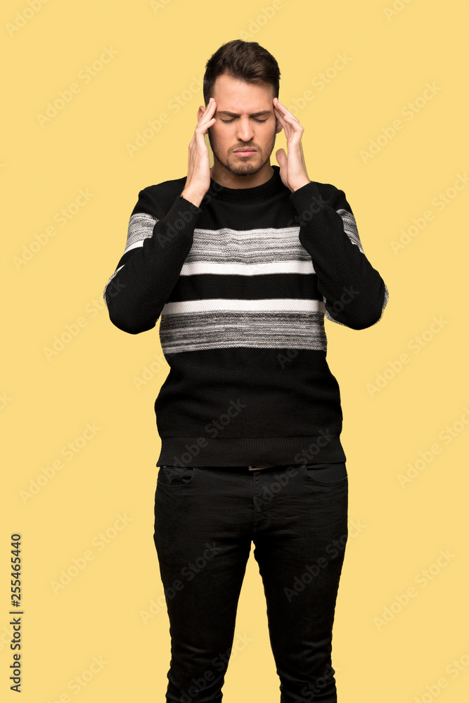 Handsome man with headache over yellow background Handsome man with headache over yellow background