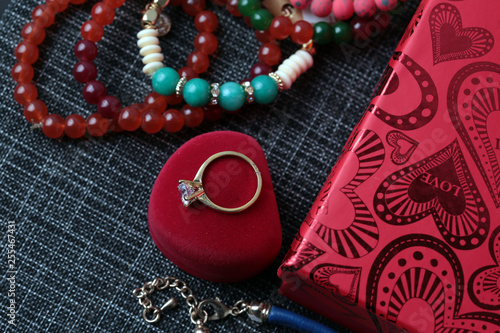 White gold diamond ring on top of colored stones. Romantic background ( Valentine's Day) 
