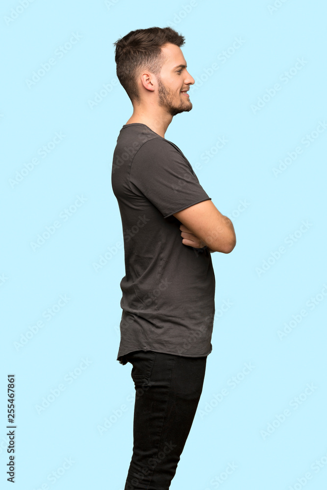 Man with black shirt in lateral position over blue background Man with black shirt in lateral position over blue background