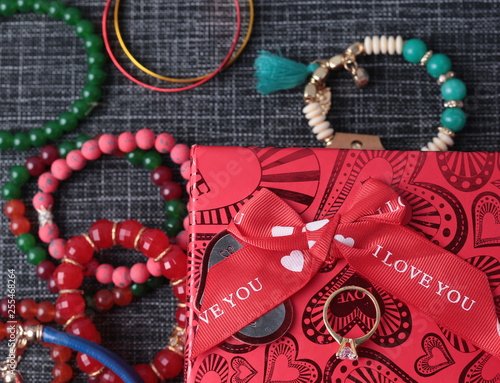 White gold diamond ring on top of colored stones. Romantic background ( Valentine's Day) 