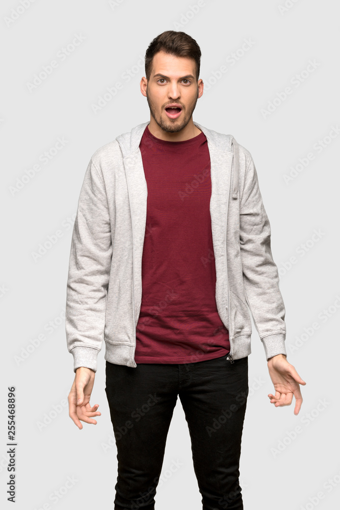 Man with sweatshirt with surprise facial expression over grey background Man with sweatshirt with surprise facial expression over grey background
