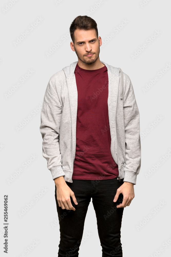 Fototapeta premium Man with sweatshirt with sad and depressed expression over grey background