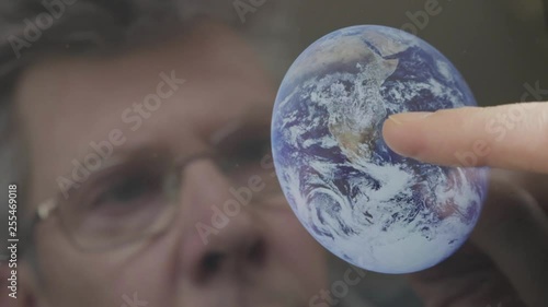 Caucasian scientist inspecting an image of the earth on a computer tablet themes of discovery astronomy earth scientist - Created with a public domain image from NASA