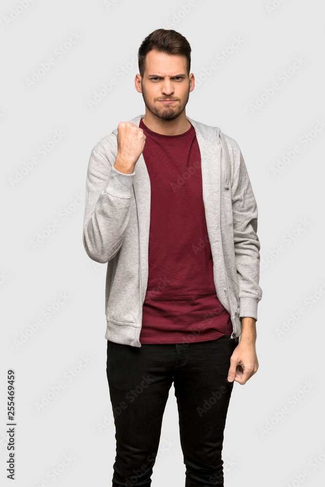 Man with sweatshirt with angry gesture over grey background Man with sweatshirt with angry gesture over grey background