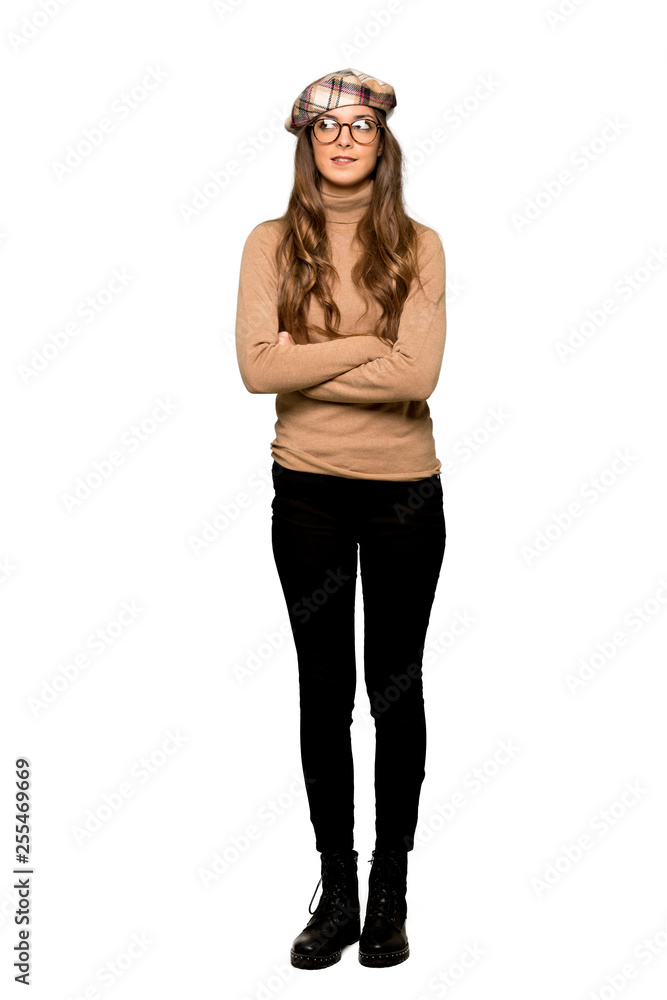 Fototapeta premium Full-length shot of Young woman with beret with confuse face expression while bites lip on isolated white background