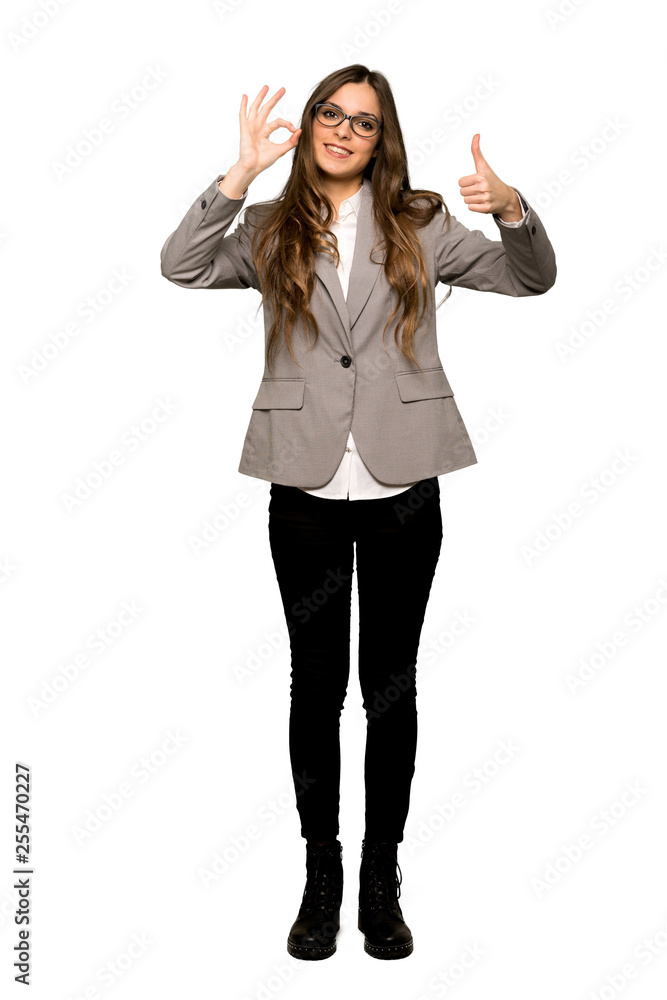 Full-length shot of Business woman showing ok sign with and giving a thumb up gesture on isolated white background Full-length shot of Business woman showing ok sign with and giving a thumb up gesture on isolated white background