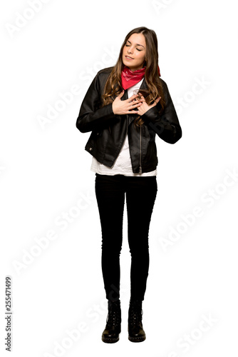 Full-length shot of Young woman with leather jacket having a pain in the heart on isolated white background