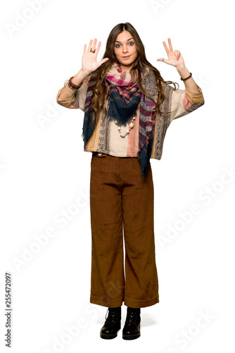 Full-length shot of Young hippie woman counting eight with fingers on isolated white background
