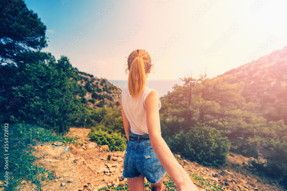 Naklejka premium Chodź za mną. Dziewczyna trzyma i prowadzi swojego chłopaka za rękę w górach