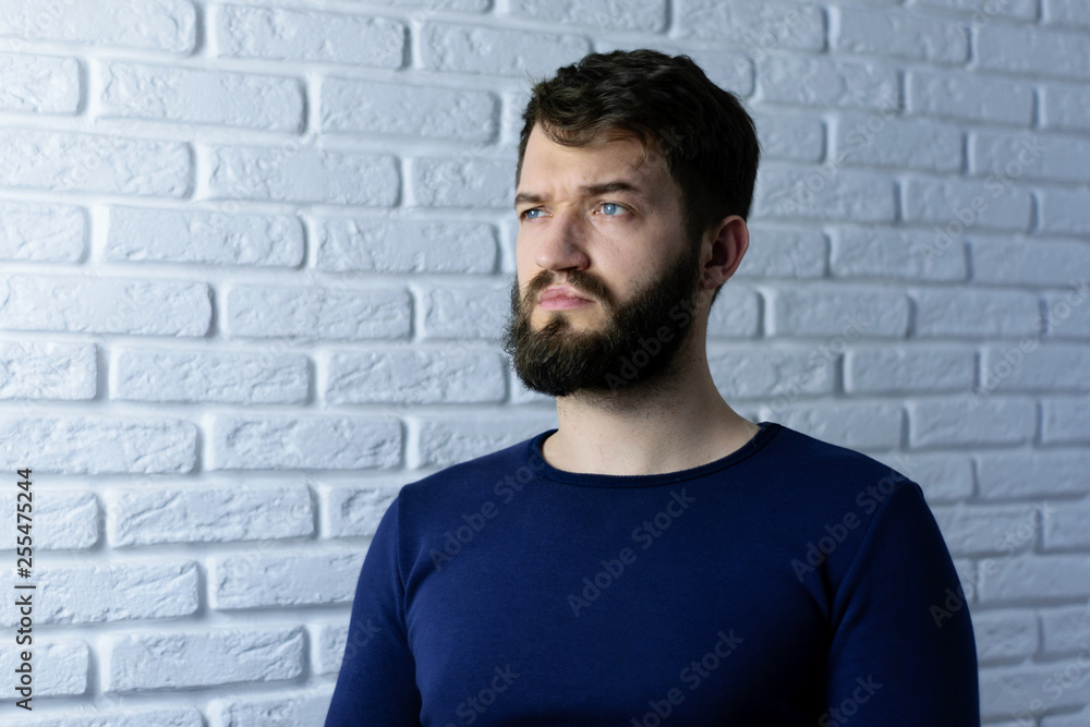 portrait of a handsome bearded man on brick wall background. Pensive hipster isolated portrait of a handsome bearded man on brick wall background. Pensive hipster isolated