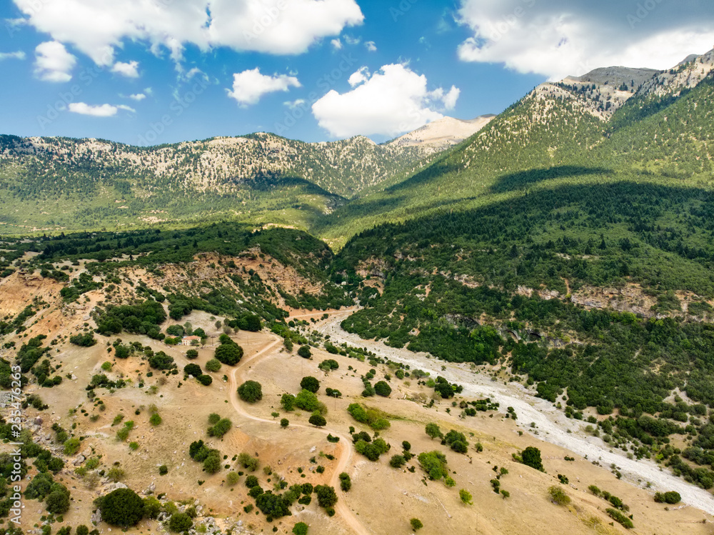 Aerial view of serpentine road snaking between mountains in West Greece. A road full of twists and turns winding sharply up the mountain in Peloponnese region, Greece.