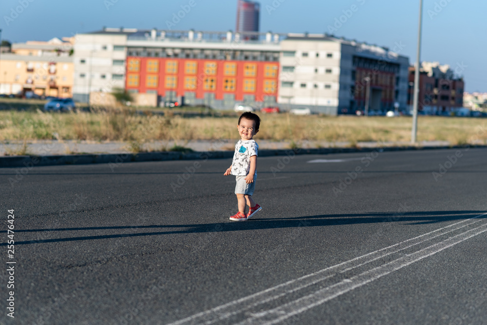 Niño pequeño jugando en carretera desierta 02 Niño pequeño jugando en carretera desierta 02
