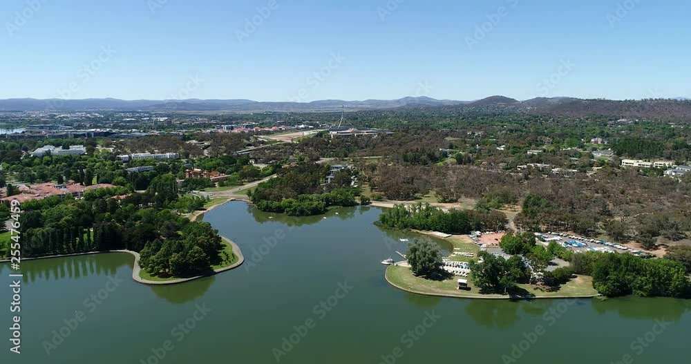 Burley Griffin lake across Canberra city in Australia with federal and government buildings and parks on its shores in aerial hovering. Burley Griffin lake across Canberra city in Australia with federal and government buildings and parks on its shores in aerial hovering.