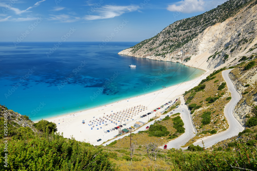 Aerial view of Myrtos beach, the most famous and beautiful beach of Kefalonia, a large coast with turqoise water and white coarse sand, surrounded by steep cliffs.