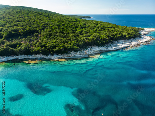 Aerial view of Emplisi Beach  picturesque stony beach in a secluded bay  with clear waters popular for snorkelling. Small pebble beach near Fiscardo town of Kefalonia  Greece.