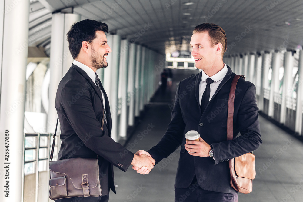 Image two business partners in elegant suit successful handshake together in modern office.Partnership approval and thanks gesture concept Image two business partners in elegant suit successful handshake together in modern office.Partnership approval and thanks gesture concept