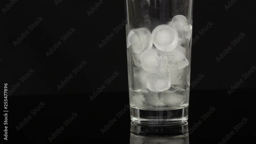 Empty long glass cup with ice on a black background Empty long glass cup with ice on a black background