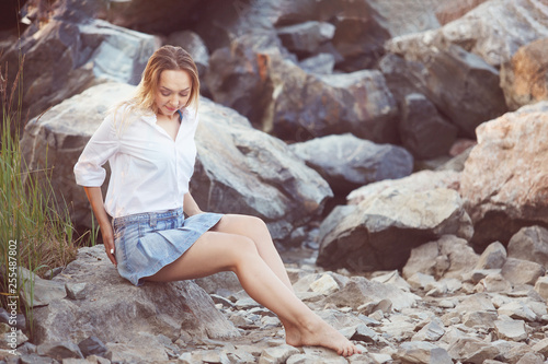 Beautiful girl sitting on the rocks.