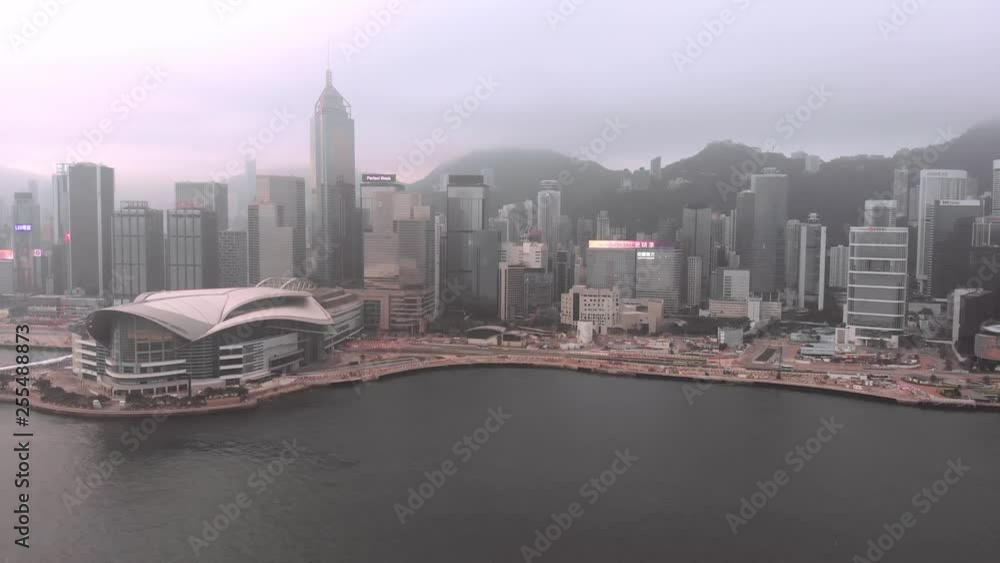 Flying over Victoria Bay in Hong Kong. Hong Kong Convention and Exhibition Center. The city and the tops of the mountains in the fog, sailing yachts across the bay Flying over Victoria Bay in Hong Kong. Hong Kong Convention and Exhibition Center. The city and the tops of the mountains in the fog, sailing yachts across the bay