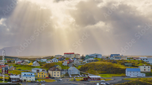 Beautiful traditional houses in Stykkisholmur the harbour village with cloudy sky and sun ray to the village , Iceland.