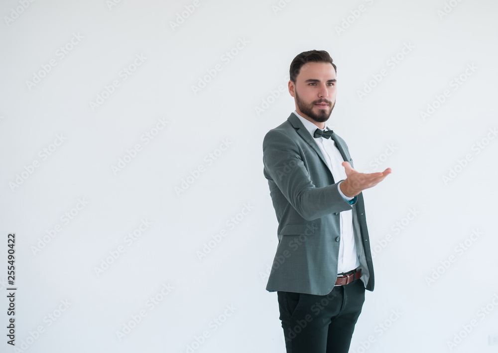 Man in formal suit standing and shows gesture outstretched hand open palm on white background with copy space for text Man in formal suit standing and shows gesture outstretched hand open palm on white background with copy space for text
