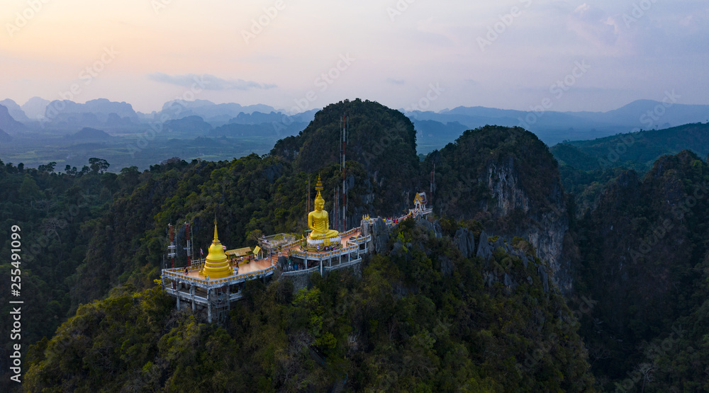 View from above, stunning aerial view of the beautiful Tiger Cave Temple (Wat Tham Sua) surrounded by amazing ridges of limestone mountains during the sunset. Krabi, Thailand.