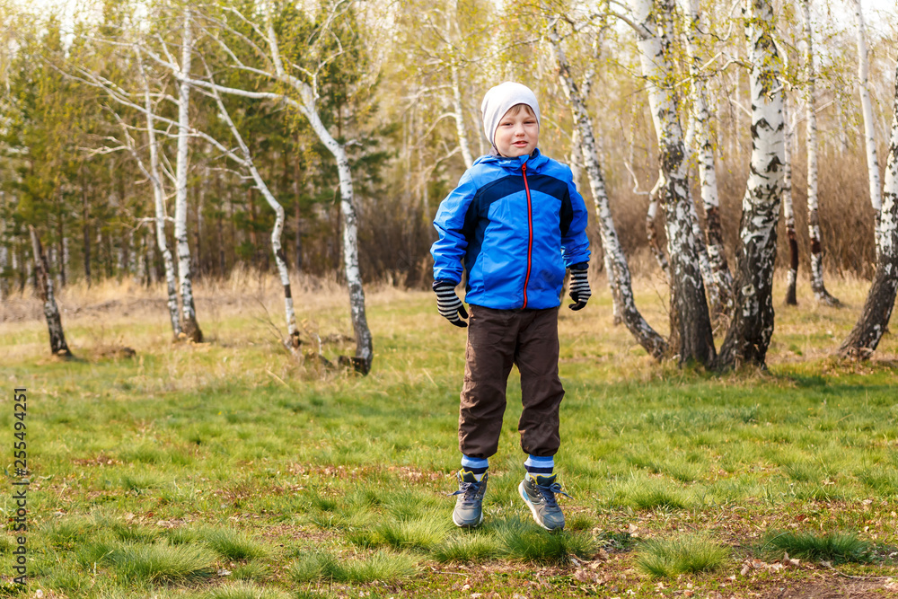 six-year-old boy jumping on the green grass six-year-old boy jumping on the green grass