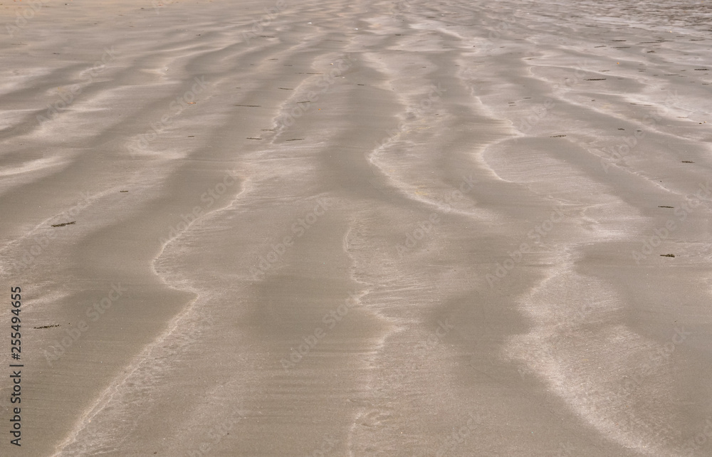 Background and texture photo of brown color sand with pile of sand from small crab and ripple shape from the sea on the beach. Background and texture photo of brown color sand with pile of sand from small crab and ripple shape from the sea on the beach.