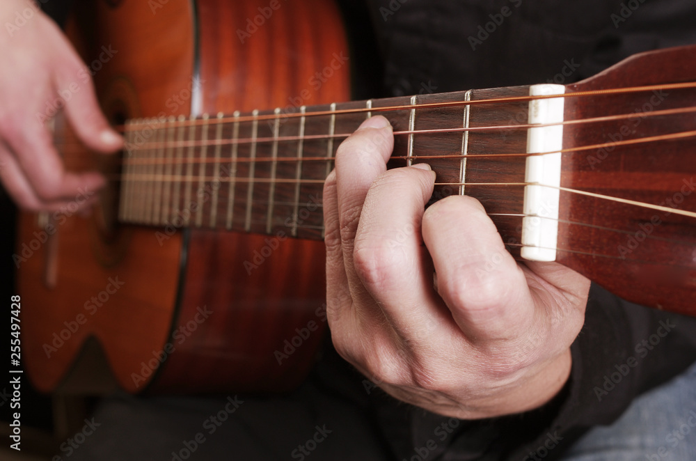 Guitarist plays the guitar. Close-up.