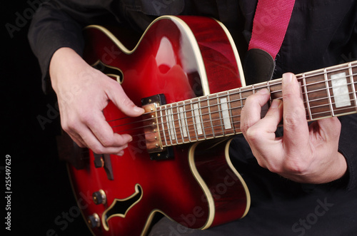Guitarist plays the guitar. Close-up.