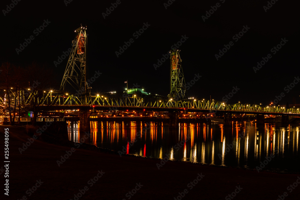 Obraz premium Reflections under bridge over river at night 