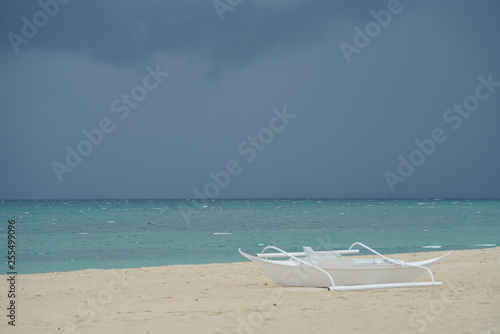 View of a wooden white boat along the beach at Lakawon, Philippines