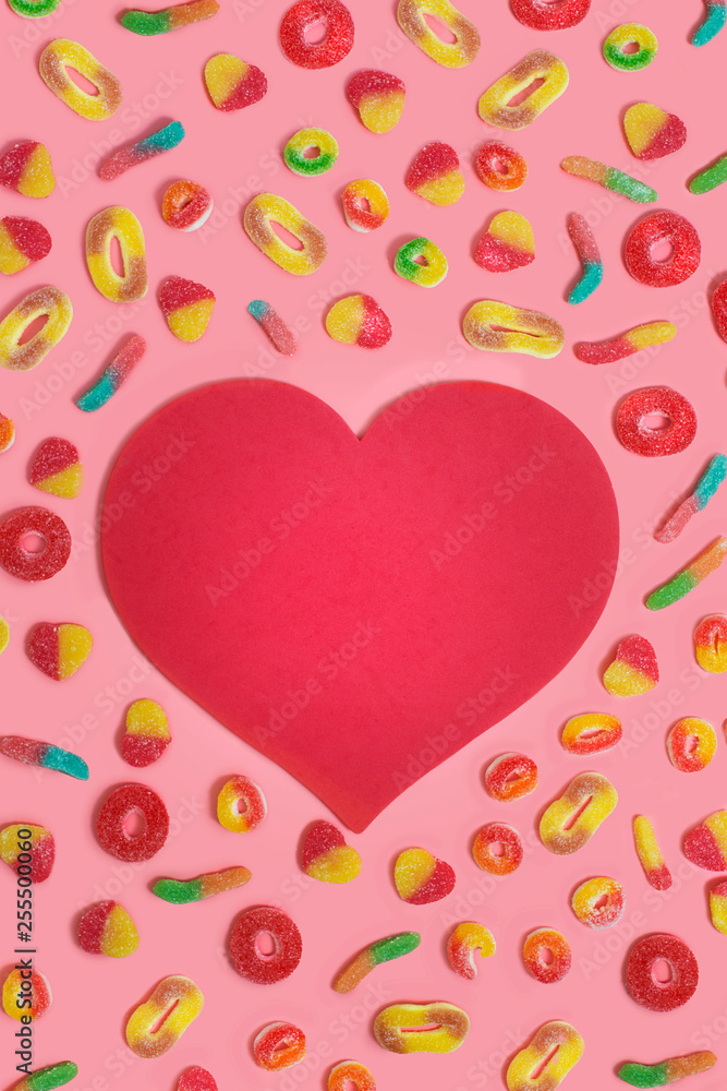 Confectionary candies and text space heart shape red background still life image.