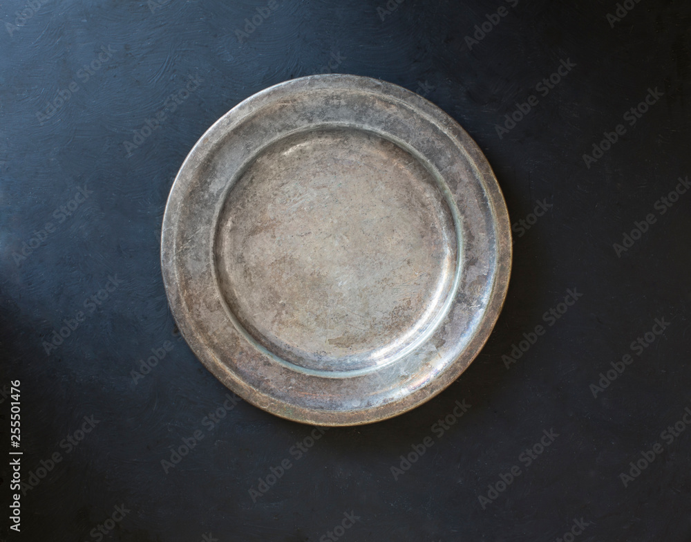 Rustic silver plate on black background Rustic silver plate on black background