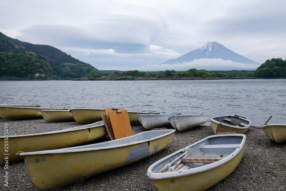 Beautiful view of Lake Saiko in Japan with the rowboat parked on the waterfront and Mountain Fuji background.